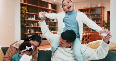 Family, fun and playing on a sofa at home to relax, bond and quality time together. A happy man, woman or parents and children in a living room for happiness, love and care with kid on shoulders.