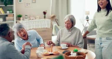 Son sınıflar, arkadaşlar ve bakımevinde gülerek ve konuşarak masada kağıt oynuyorlar. Yaşlı kadınlar, çay içen erkek ve bakıcı ve bağlanmak ve emeklilikte birlikte rahatlamak için bir oyun..