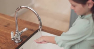 Temizlik, mutfak lavabosunda sabunu olan kız ve çocuğun elleri ve bakteri, çamaşır ve sağlık için hijyen hakkında bilgi. Ev, özbakım ve temiz ellerle mikroplar, virüsler ya da pislikler için su..