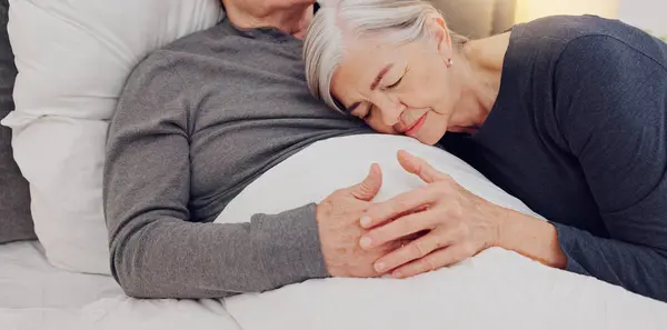 Hug, bed and senior couple in home for bonding, relationship and care for recovery in home. Marriage, retirement and elderly man and woman embrace in bedroom for healthcare, nursing and wellness.