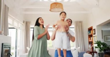 Family, applause and celebration of child in home, bonding and having fun on birthday. Happy, kid and father and mother clapping, lifting boy and excited to play together in house party with energy.