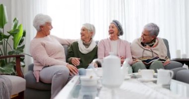 Üst düzey kadınlar, komik ve arkadaşlar evde oturma odasında, kaynaşıyor ve birlikte gülüyorlar. Mutlu, yaşlı bir grup ve dinlenme odasındaki insanlar, komedi için sohbet, gülümseme ve emeklilik için dinlenme..