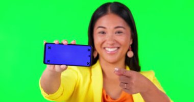 Kadın yüzü, yeşil ekran ve el stüdyonun arka planında takip işaretleri olan telefon modelini gösteriyor. Portre, boşluk ve Asyalı kadın haber için ürün yerleştirme ya da uygulama için nasıl adım atılacağını gösteriyor.