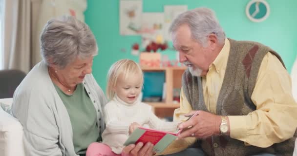 読書や祖父母の家庭での女の子のためのサポートとの結合を支援する シニア男性 祖母と愛を持って家で子供のための学習と教育のための本を持つ子供 — ストック動画