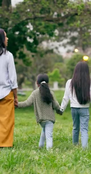 公園で歩いたり 手を握ったり 家族を抱えたり 自然と自由に結びつけたり 後ろからサポートしたりします 庭に緑の田舎で木 自然な屋外の愛と子供たち — ストック動画