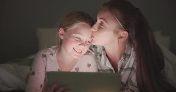 平板电脑 妈妈带着女儿在卧室里讲故事 流连忘返 看电影 与家庭中的妇女和女孩接吻 上网和技术 供网上和夜间订阅费用 — 图库视频影像