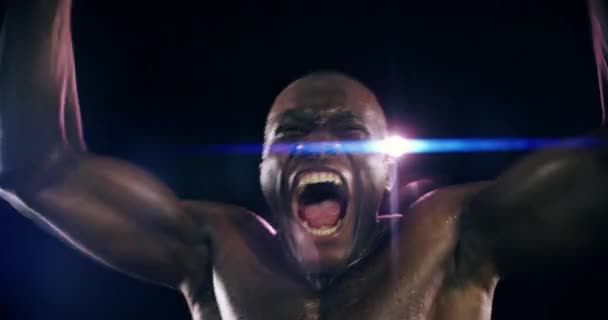 フィットネスパワー 競争の成功 Mmaで勝利 暗黒の背景で戦ったりレスリング スタジオレンズフレアでのスポーツの達成で興奮するアフリカチャンピオンの顔 — ストック動画