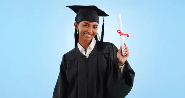 Graduate woman, diploma and portrait in studio with pride, success and achievement by blue background. Graduation, girl and certificate with award, celebration or learning for future from university.
