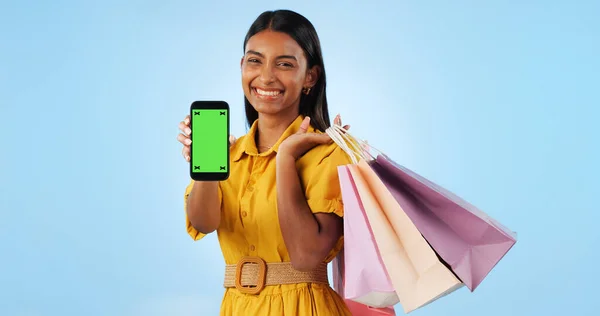 Phone green screen, shopping bag and portrait of happy woman show online discount, sales deal info or studio promo. Tracking markers, cellphone chroma key and mockup space customer on blue background.