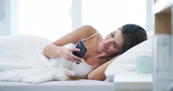 早上在卧室里打字 阅读社交媒体通知或滚动移动应用程序时 女人和电话 智能手机 放松或醒来后在床上搜索互联网 联系人或网络 — 图库视频影像