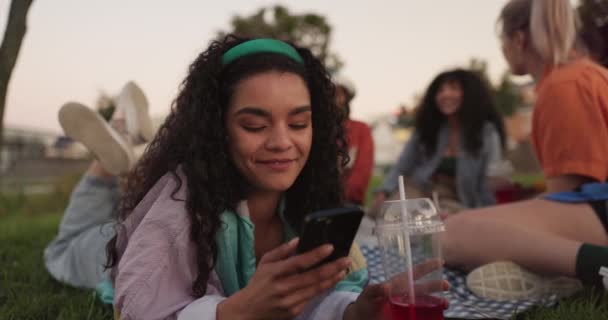 快乐的女人 打电话和朋友一起在公园里放松一下 进行社交媒体 交流或户外野餐 女人笑着躺在草地上或毛毯上 用手机在网上聊天 — 图库视频影像