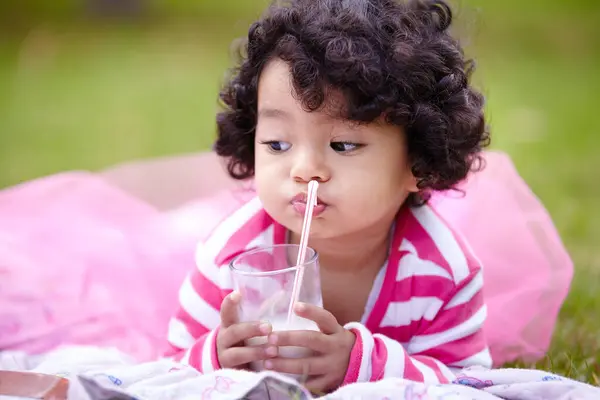 躺着野餐的时候 在草地上喝着牛奶 用粉红的吸管吸着稻草 卷发和乳制品儿童均衡饮食 营养和钙 以促进强壮骨骼的发育 — 图库照片