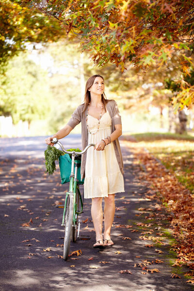 Bicycle, woman and nature for fitness in cycling, summer vacation and eco friendly park with wellness and exercise. Norway, person and trendy fashion in garden, sustainability and happy in cityscape.