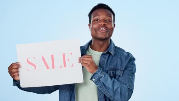 海报和销售与一个蓝色背景的黑人男子在工作室零售购物 与持有纸质信息的快乐年轻人的肖像 微笑和签约 打折或讨价还价 — 图库视频影像