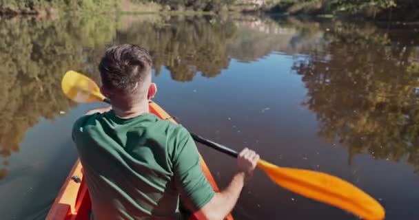 フィットネス カーディオ または自然の中で楽しい旅や冒険のためのカヤックでのスポーツ 湖と人の背中 トレーニングや運動 趣味や自由のためのパドルで川の男の後ろにボート ローイング — ストック動画