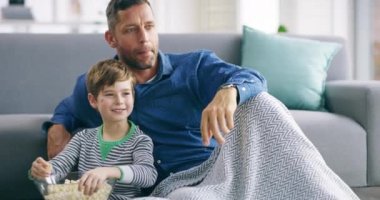 Aile, patlamış mısır ve oğluyla birlikte oturma odasındaki kanepede televizyon izleyen bir baba. Bir dairede film, film ya da video izleyen bir çocukla mutlu ya da mutlu..