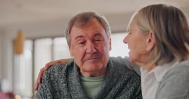 Aşk, mutlu ve son sınıf çifti modern evdeki oturma odasında özenle sarılıp birbirlerine bağlanıyorlar. Gülümse, nazik ve yaşlı bir adam ve kadın emeklilikte sarmaş dolaş.