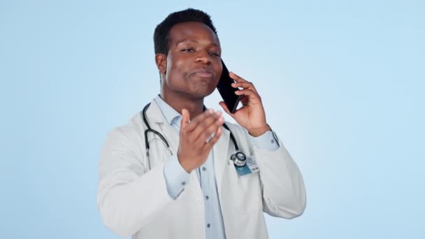 医生和电话在工作室进行沟通 咨询或讨论蓝色背景与微笑 黑人和智能手机专家 用于远程保健或对话 — 图库视频影像