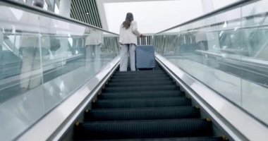 Havaalanı, bavul ve iş adamlarının uluslararası seyahat ve ulaşım için yürüyen merdivendeki arka görüntüsü. Seyahat ya da seyahat için bavulları olan şirketler, küresel ve profesyonel işçiler..