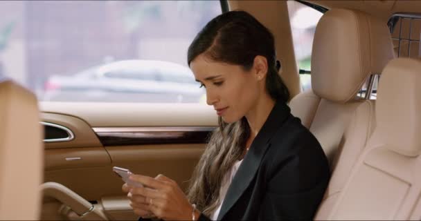 通勤中のソーシャルメディア ミーム コミックのための電話を持つタクシー ビジネス女性 ソーシャルメディア 運転手のフィードバック調査のためのスマートフォンアプリを搭載した車 サービス 女性の乗客 — ストック動画