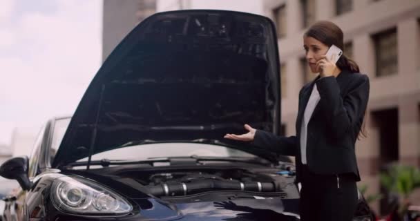 ビジネス女性 車の故障 ストレス 街頭での通話 エンジニア またはイライラするための質問を持つスマートフォンの起業家 モーター エンジンのトラブル — ストック動画