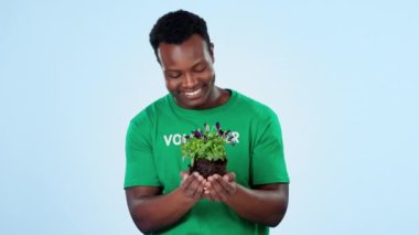 Gönüllü, mutlu siyah adam ya da bitki kokusu sosyal sorumluluk için çiçek ya da toprak, toplum hizmeti ya da Dünya Günü. Sürdürülebilir çevre, stüdyo çiçeği veya mavi arka planda yardım aktivisti.
