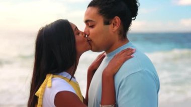 Aşk, sevgili ve tatilde ya da tatilde sahilde öpüşen bir çift. Seyahat, romantizm ya da genç bir erkek ve kadınla okyanus kıyısında kaynaşma yıldönümü..