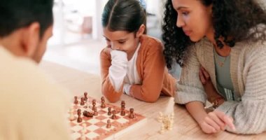 Aile, anne ve çocuk oyun öğretirken veya öğrenirken evde satranç oynuyorlar. Latin kadın ve kız çocuk birlikte eğlenmek, şah mat etmek ya da kaliteli zaman geçirmek ve yakınlaşmak için yarışmak için oynuyorlar..