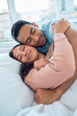 Genç melez çift sabah erkenden yatakta uzanıp birbirlerine sarılıyorlar. Yakışıklı Asyalı adam, güzel İspanyol karısını evinde uyurken tutuyor. Kendini güvende ve kollarında korunmuş hissediyor..