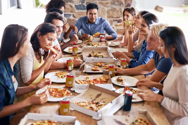 Whats better than pizza with friends. a group of friends enjoying pizza together