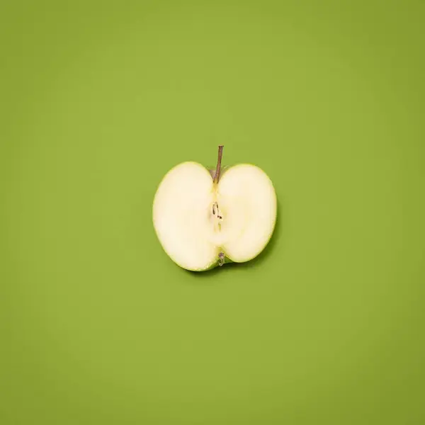 Cut into your health. a green apple against an empty studio background