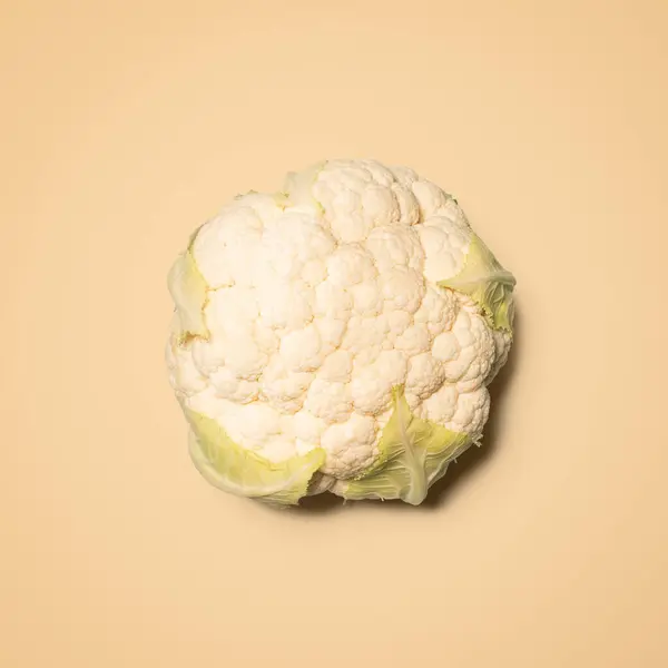 White sauce makes this outstanding. a head of cauliflower against an empty studio background