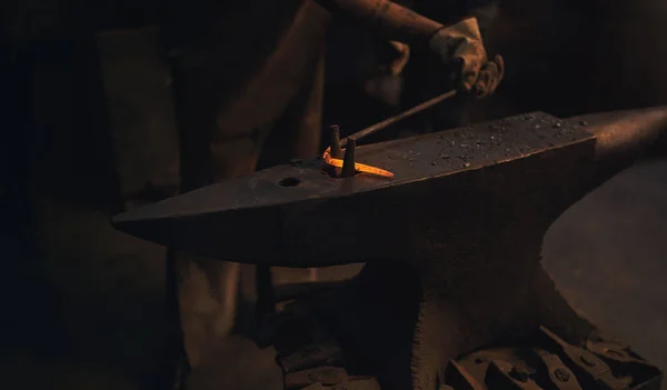 Whats bent can be just as beautiful. a blacksmith working with a hot metal rod in a foundry