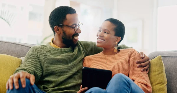 Hug, home tablet and black couple happy for social media post, morning wellness blog or relationship romance. Living room sofa, eye contact and African man, woman or marriage people embrace for love.