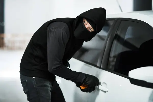 誰かが来るのを聞いたと思う 駐車場の中の 車のドアの鍵を拾った 仮面刑事 — ストック写真