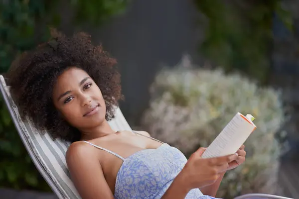 Theres nothing like a good book and sunshine. an attractive ethnic female with a book outdoors