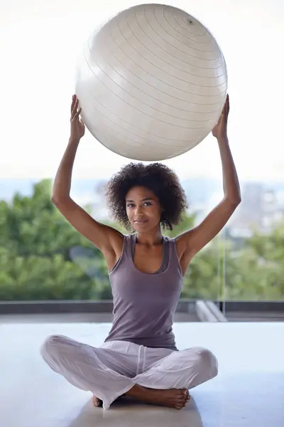 You should really try this...Full-length portrait of an attractive young woman holding up an exercise ball
