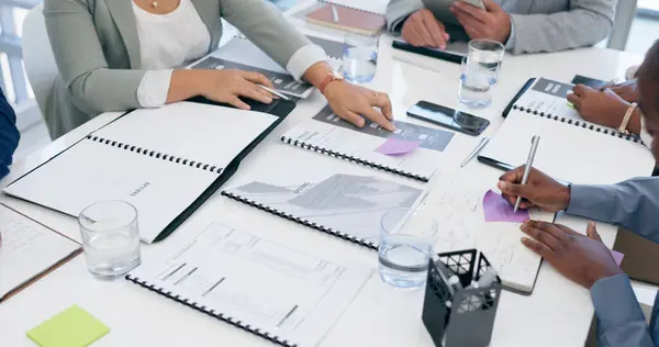 Business people, hands and writing with documents in planning, schedule or meeting on office table. Closeup of employee group with paperwork for tasks, strategy or brainstorming ideas at workplace.