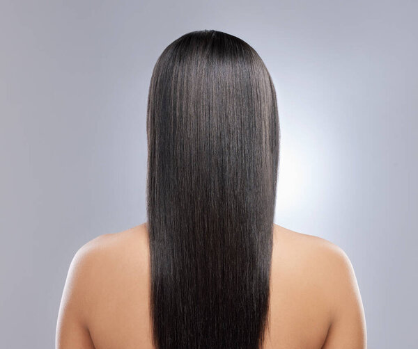 Her hair is healthy and beautiful. Rearview shot of a woman with long brown hair