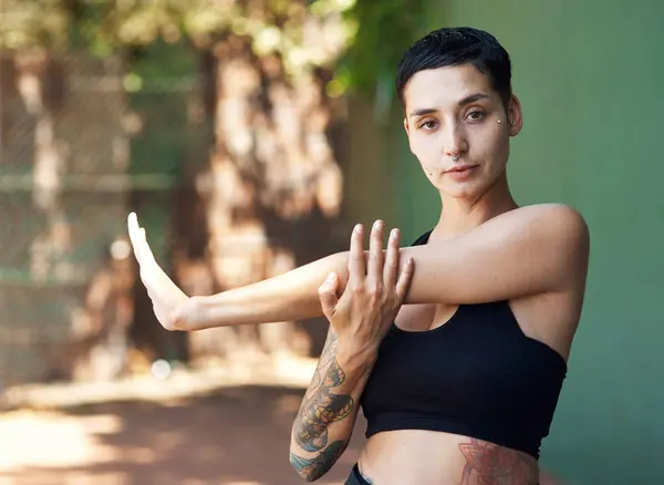 stock image You cant ball without warming up. Cropped portrait of an attractive young female athlete stretching while standing on the basketball court