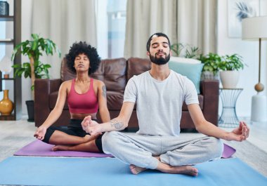 Yoga ilişkimizi güçlendirdi. Oturma odasında yoga yapan genç bir çift.