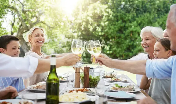 When family gets together, it calls for a celebration. a family sharing a toast while enjoying a meal together