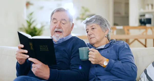 Coffee, bible and a senior couple in their home to read a book together during retirement for religion. Faith, belief or spiritual with an elderly man and woman learning about god in the living room.