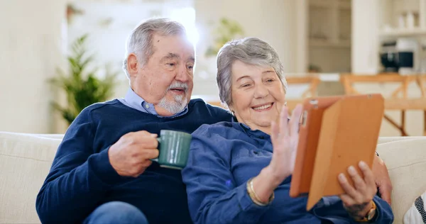 Tablet, coffee and a senior couple in their home to relax together during retirement for happy bonding. Technology, smile or love with an elderly man and woman drinking tea in their living room.