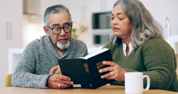 Reading book, old couple or bible in home for faith, religion or God with hope for worship in house. Studying Jesus Christ, holy spirit or Christian people learning literature or spiritual prayer.