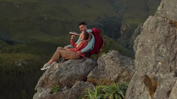 Hiking, mountain and drinking water, couple relax on outdoor adventure and peace in nature with romance. Trekking, rock climbing and love, man and woman with view of natural cliff with sharing drink