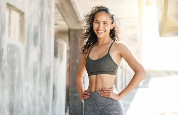 stock image Working for the body of my dreams. an attractive young woman standing alone in the city during her outdoor workout