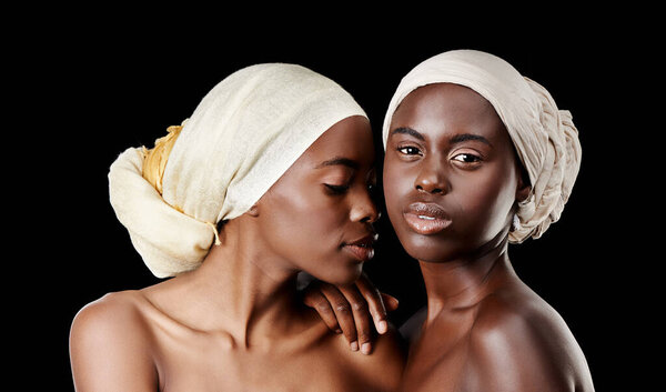 Shes more like a sister than a best friend. Studio portrait of two beautiful women wearing headscarves against a black background