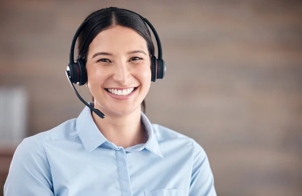 Portrait of a smiling mixed race call centre agent looking happy and positive while wearing a headset. Female customer service worker using headset and consult with clients online.