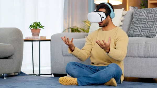 Lounge, virtual reality glasses and man with connection, gaming and headphones with stress relief. Person, home or player with esports, online gaming or VR eyewear with metaverse, futuristic or relax.